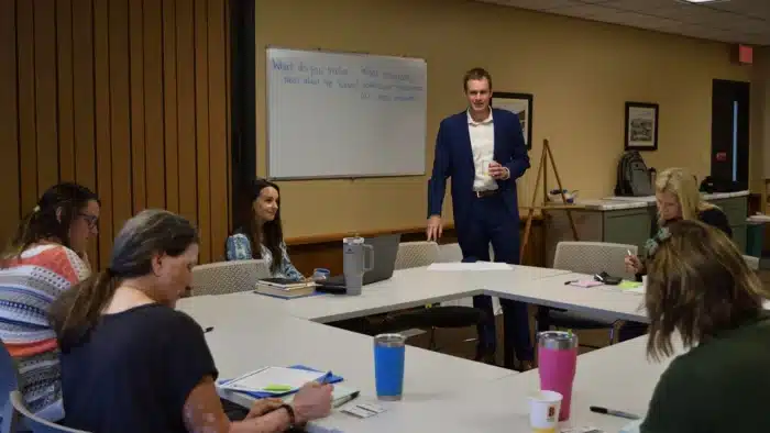 Team participating in a strategic planning workshop led by a facilitator, discussing organizational priorities and decision-making